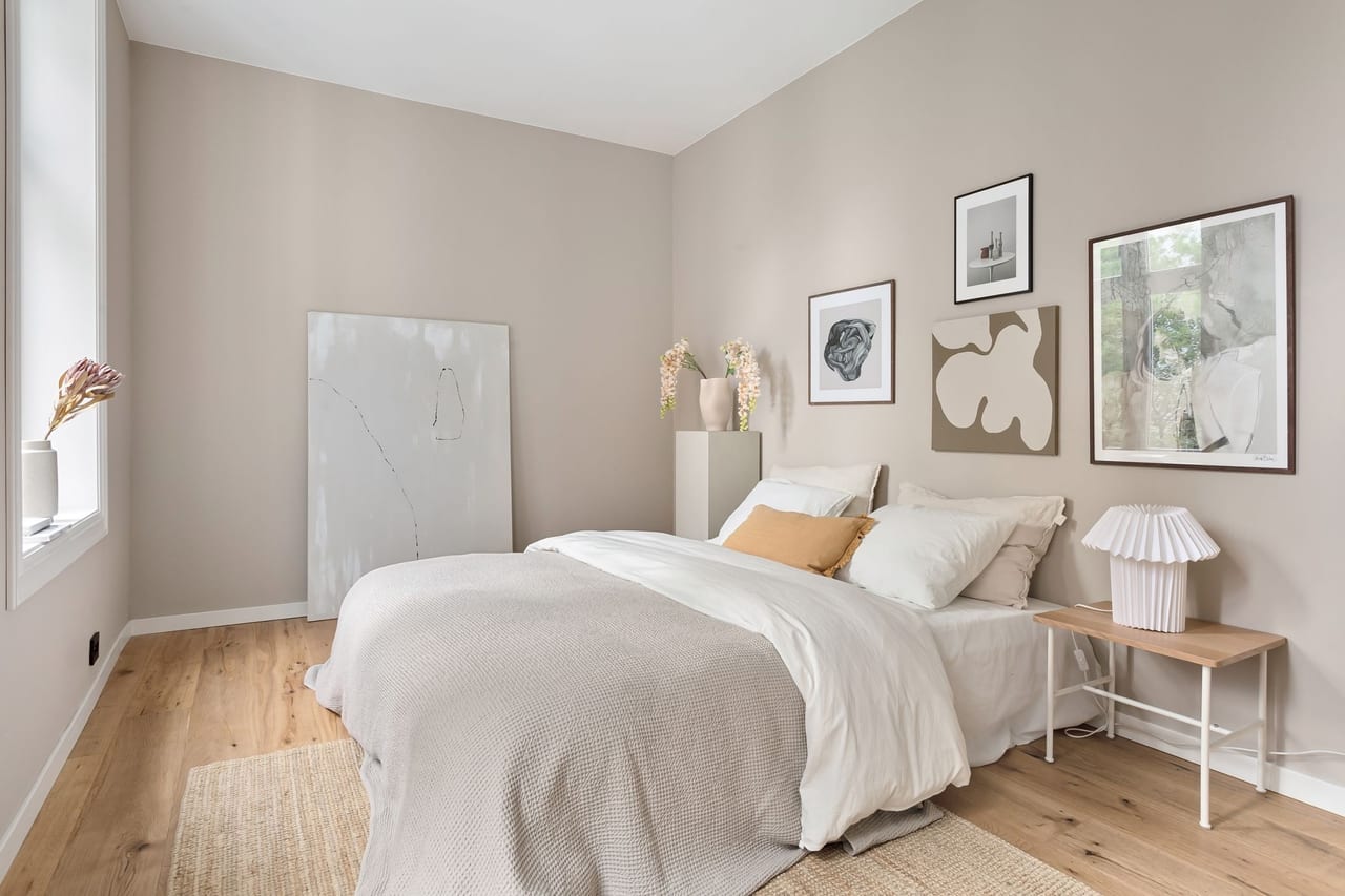 Slaapkamer met ingelijste posters boven het bed