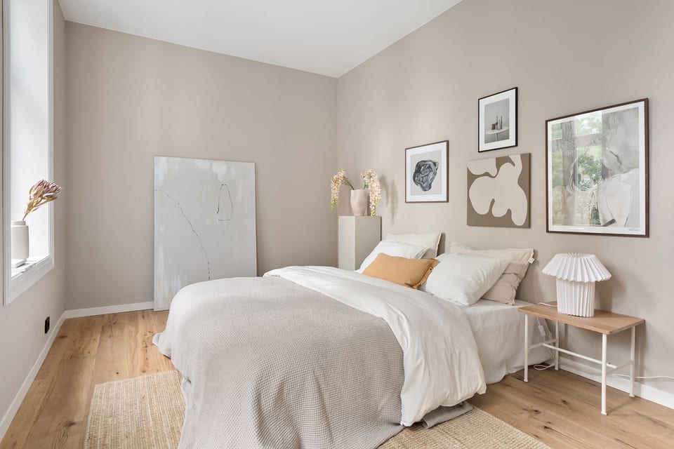 Slaapkamer met ingelijste posters boven het bed